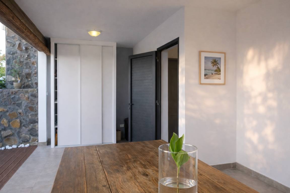 Entrée de la villa avec mur en pierre et grande table en bois