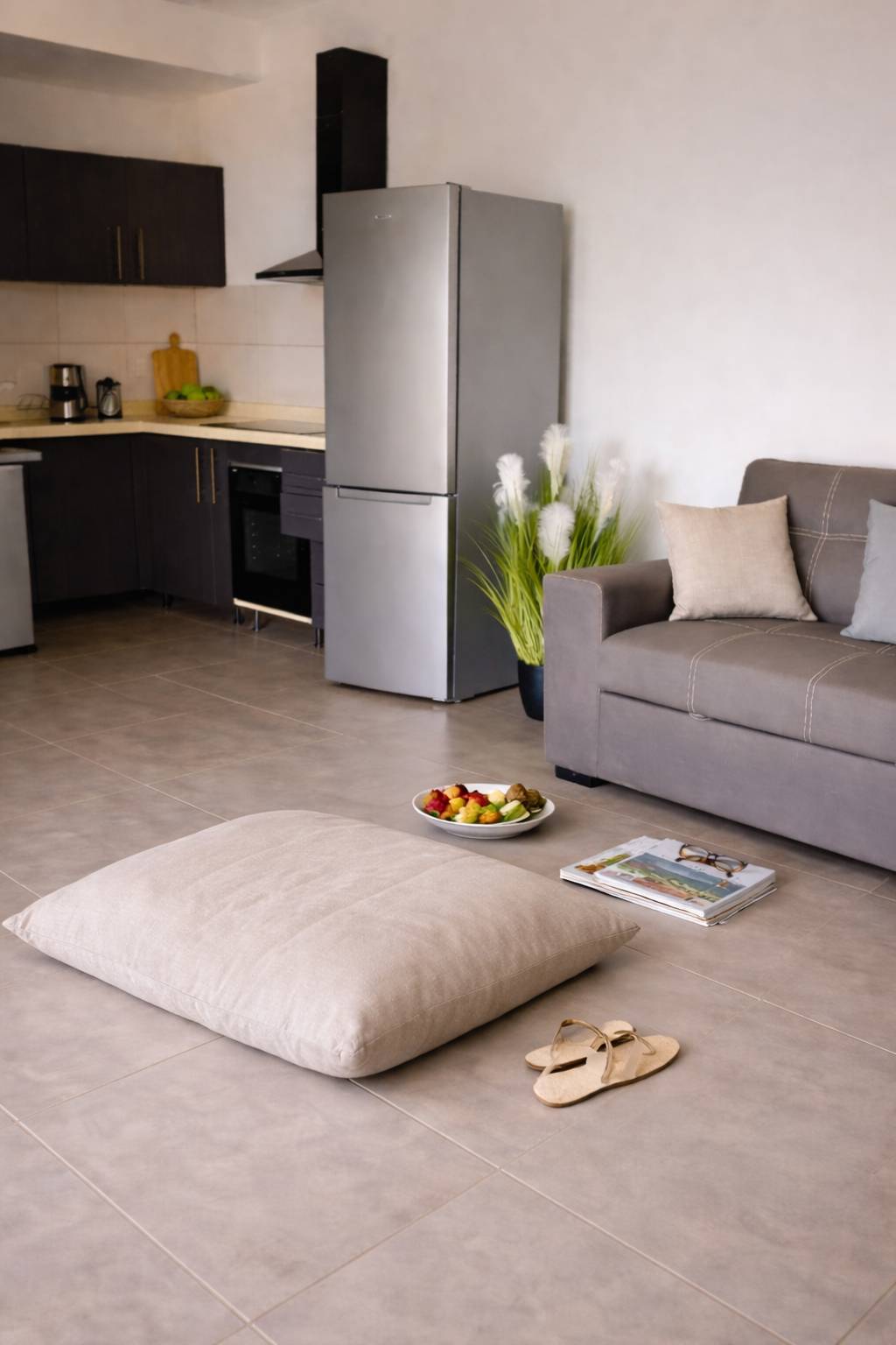Séjour ouvert sur la cuisine équipée avec canapé confortable